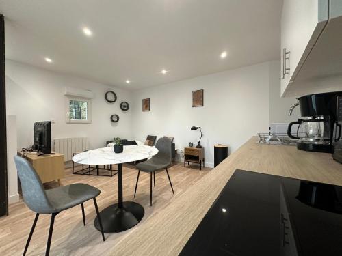 une cuisine et un salon avec une table et des chaises dans l'établissement Le Viennois, cosy et calme, à Saint-Junien