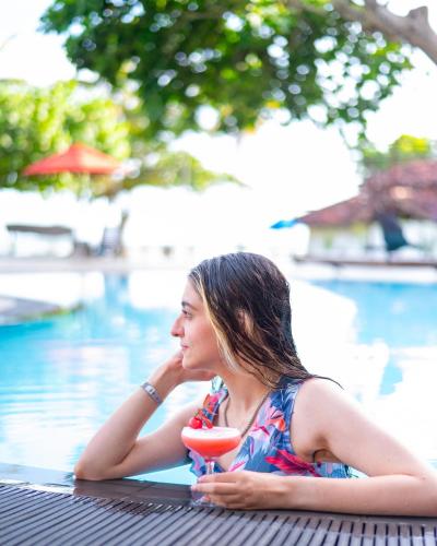 a woman laying on a table next to a swimming pool at The Palms in Bentota