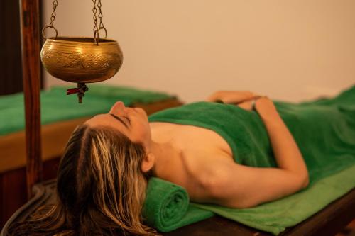 a woman in a green dress laying on a bed at The Palms in Bentota