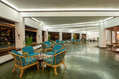 a lobby with blue chairs and a table in a building at The Palms in Bentota