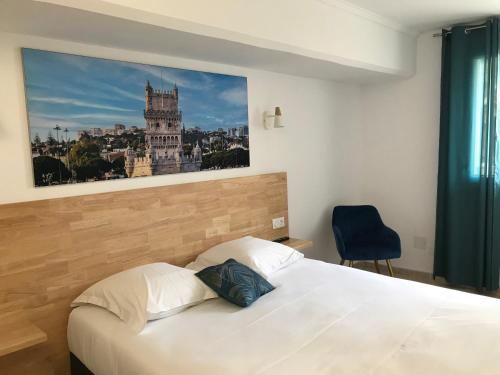 a bedroom with a white bed with a picture on the wall at Privilège Hôtel & Apparts Eurociel Centre Comédie in Montpellier