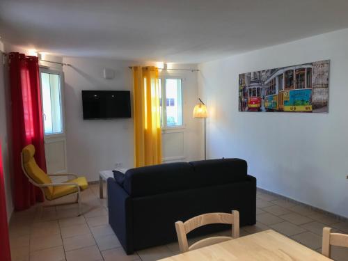 a living room with a black couch and a yellow curtain at Privilège Hôtel & Apparts Eurociel Centre Comédie in Montpellier