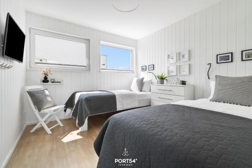 a bedroom with two beds and a chair in it at Ferienhaus Key West Olpenitz in Olpenitz