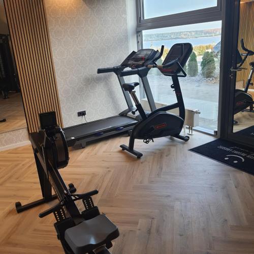 a gym with two treadmills and two exercise bikes at schwimmende Ferienwohnung Sundowner in Elsterheide