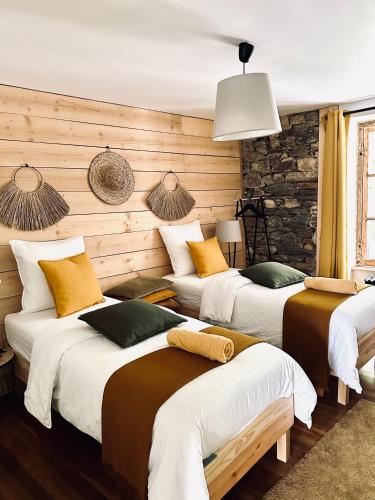 - 3 lits dans une chambre dotée de murs en bois dans l'établissement La Maison des Vignes - Terrasse & balcon, à Morlaix