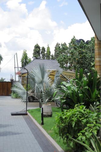 a garden with palm trees and a house at Jacomo Residences in Dar es Salaam
