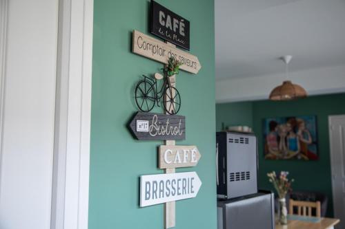 a bunch of signs hanging on a wall in a kitchen at Les bottines in Pont-d'Ouilly