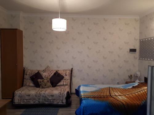 Un dormitorio con dos camas y un sofá. en Zhenis street, en Astana