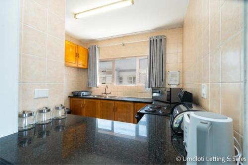 a large kitchen with a sink and a counter at Coastal Nest in Durban North