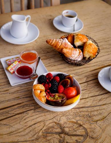 een tafel met een fruitschaal en een schaal met gebak bij Hôtel Eze Hermitage in Èze