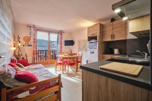 une cuisine et une salle à manger avec une table et une cuisine avec un comptoir dans l'établissement Appartement Familial De Montagne, à Villard-de-Lans