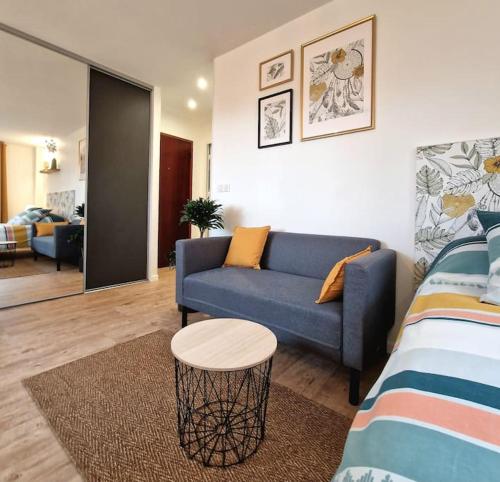 un salon avec un canapé bleu et une table dans l'établissement Le Boléro - Studio, à Dijon
