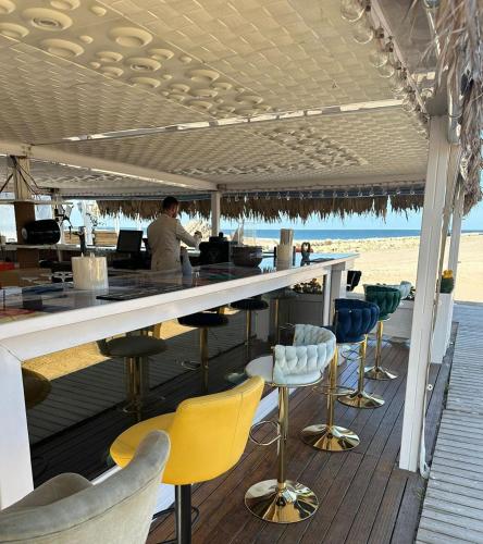 a bar on the beach with yellow and blue chairs at Boutique Citadel in Eforie Nord