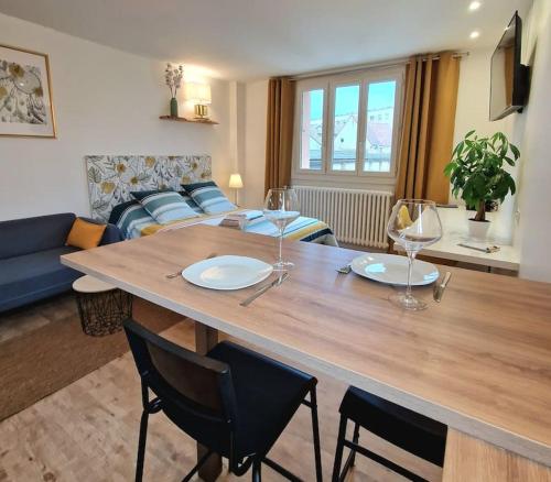 un salon avec une table avec des chaises et un canapé dans l'établissement Le Boléro - Studio, à Dijon