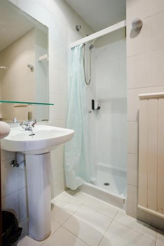 a white bathroom with a sink and a shower at Moon Hostel Bio in Bilbao