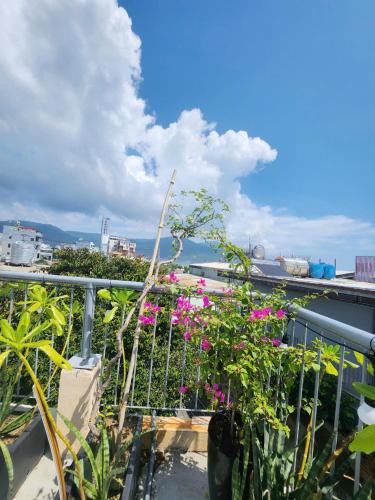 a balcony with pink flowers on top of a building at Nguyên căn 4 giường YA Beach Da Nang in Da Nang