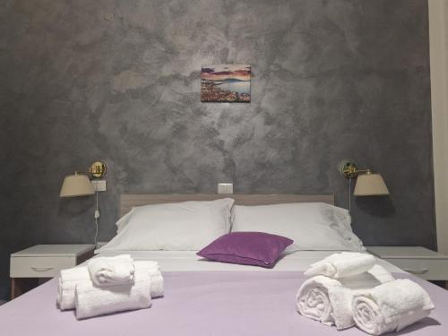 a bedroom with a bed with towels on it at Hotel Le Orchidee in Naples