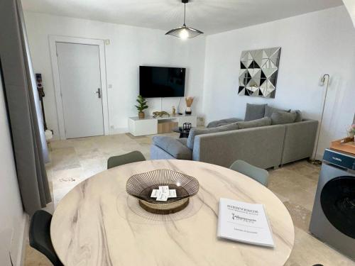 a living room with a table and a couch at Les Appartements du Mas - Aventurine in Aigues-Mortes