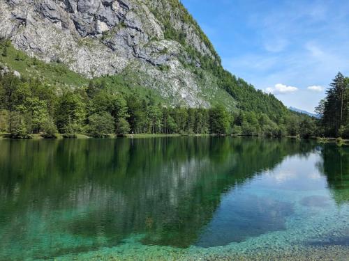 a lake in front of a mountain with its reflection in the water at Privatzimmer und Küche mit Balkon und Ausblick in Golling an der Salzach