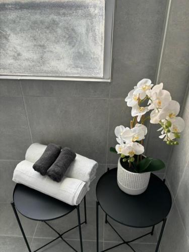 a bathroom with two chairs and a vase with white flowers at 30 on 6th in Bellville