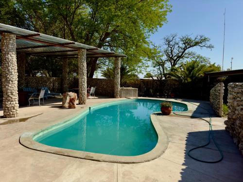 una piscina in un cortile con un padiglione di Eldorado Lodge a Okaukuejo
