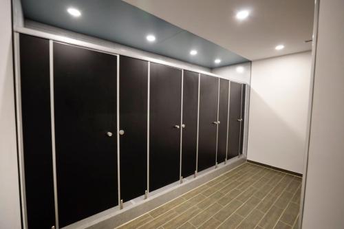 a locker room with black doors and a tile floor at 사이공 트래블 라운지 Saigon Travel Lounge in Ho Chi Minh City