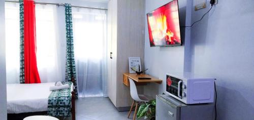 a small room with a bed and a tv at VIVI GRAY ,Muthiga, Waiyaki Way in Nairobi
