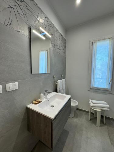 a bathroom with a sink and a mirror and a toilet at Residence Cervia in Cervia