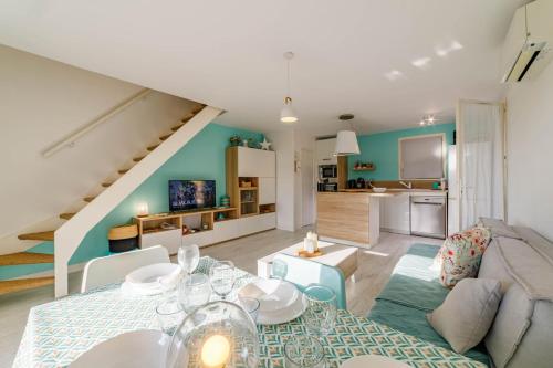 a living room with a dining table and a kitchen at Évasion à Carqueiranne - Animal ok & terrasse in Carqueiranne
