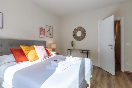 a bedroom with a white bed with colorful pillows at Sunlit Heaven in Siena