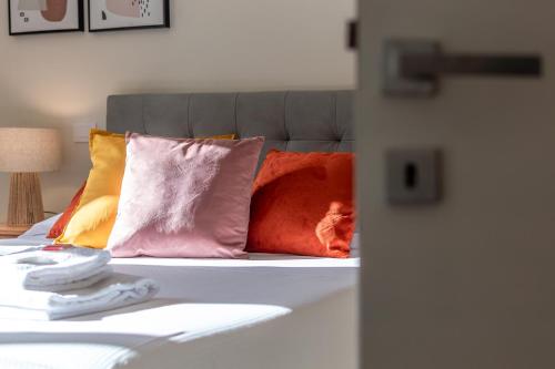 a bed with colorful pillows on top of it at Sunlit Heaven in Siena