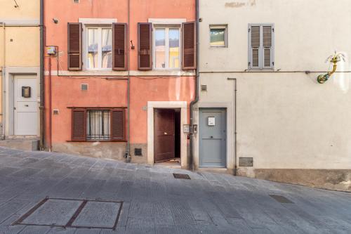 an empty street with buildings and a door at Sunlit Heaven in Siena