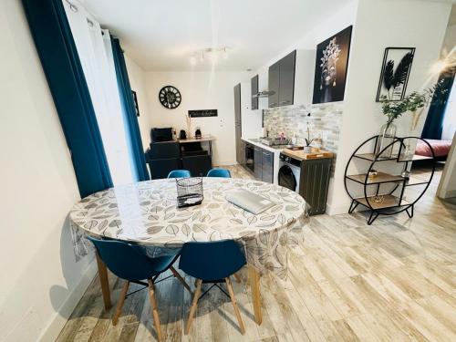 une salle à manger avec une table et des chaises et une cuisine dans l'établissement Les Appartements du Mas - EMERAUDE, à Aigues-Mortes