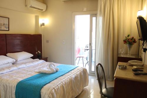 a hotel room with a bed and a desk and a window at Pharaohs Hotel in Cairo