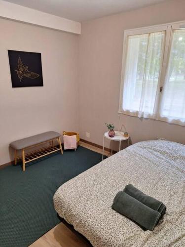 - une chambre avec un lit, une fenêtre et un banc dans l'établissement T4 rennais -Métro & Rocade, à Rennes