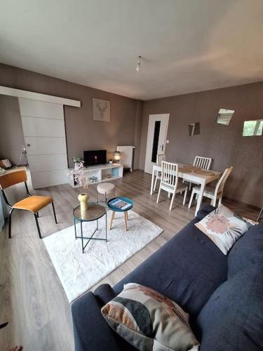 un salon avec un canapé bleu et une table dans l'établissement T4 rennais -Métro & Rocade, à Rennes