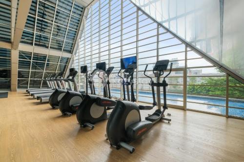 a row of exercise bikes in a gym with a large window at Jatayu by Kozystay - Paskal in Bandung
