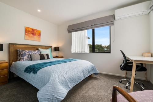 a bedroom with a bed and a desk and a window at Auckland ONE Tree Hill Coby Suit in Auckland