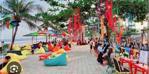 a group of people sitting on a beach with umbrellas at Nguyên căn 4 giường YA Beach Da Nang in Da Nang