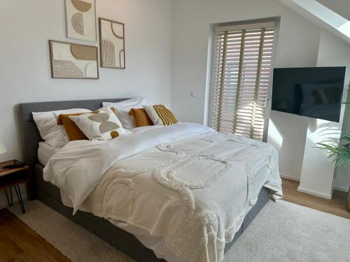 a bedroom with a large bed with white blankets and pillows at Guestroom Meerbusch in Meerbusch