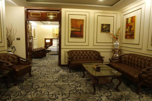 a living room with couches and a table in a room at Royal Swiss Lahore in Lahore