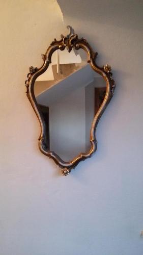 a mirror on a wall with a candle in it at Villa Fiorita in Monfalcone