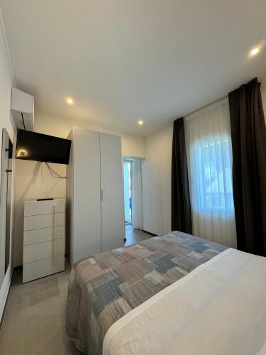 a bedroom with a large bed and a white cabinet at Residence Cervia in Cervia