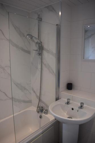 a white bathroom with a sink and a shower at 3 Bedroom-Kelpies Serviced Apartments Burns in Falkirk