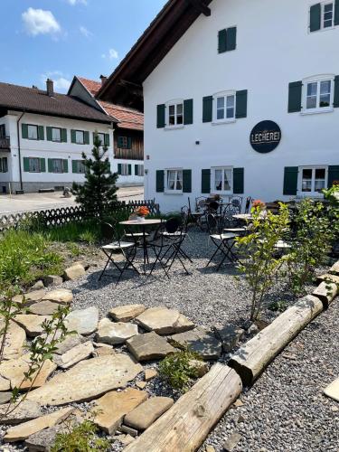 a patio with a table and chairs in front of a building at die Lecherei in Lechbruck