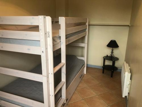 une chambre avec deux lits superposés dans une chambre avec une lampe dans l'établissement Maison à louer, à Casteljaloux