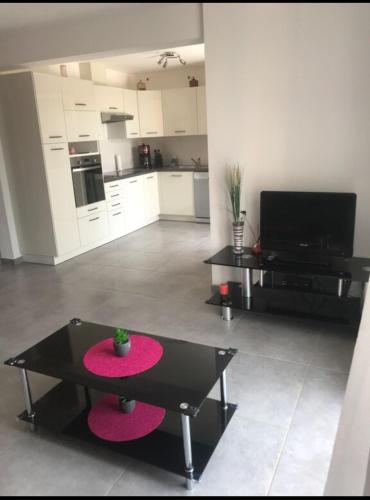 un salon avec une table noire et une cuisine dans l'établissement Charmante Maisonnette t2bis plaine de Calenzana, à Calenzana