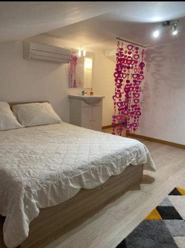 - une chambre avec un lit orné de décorations roses sur le mur dans l'établissement Charmante Maisonnette t2bis plaine de Calenzana, à Calenzana