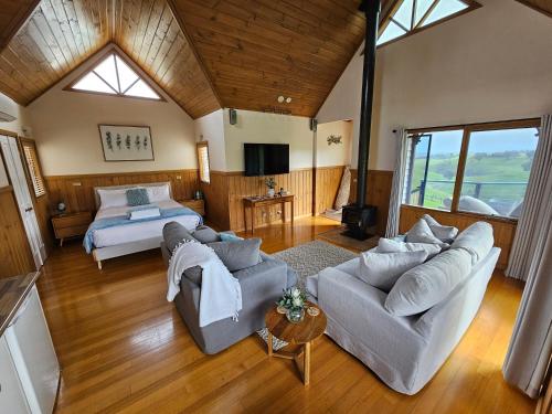 un soggiorno con un divano e un letto di Maple Ridge Cottages a Dumbalk