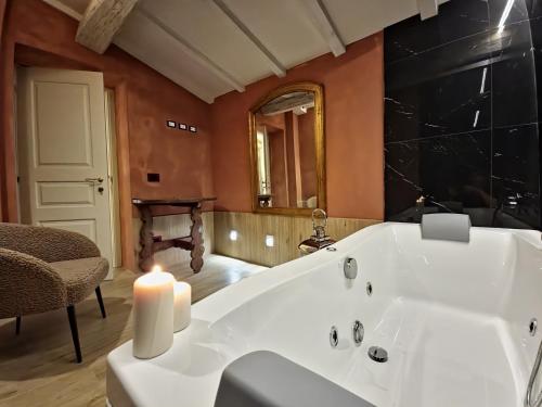 a bathroom with a large white bath tub with a candle at Villa Ginori 1755 in Londa